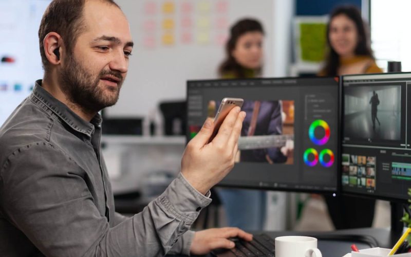 video-editor-discussing-online-with-customer-designer-holding-smartphone-1.jpg